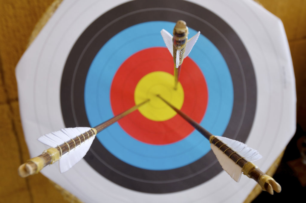 Colorful target with three arrows piercing bulls eye